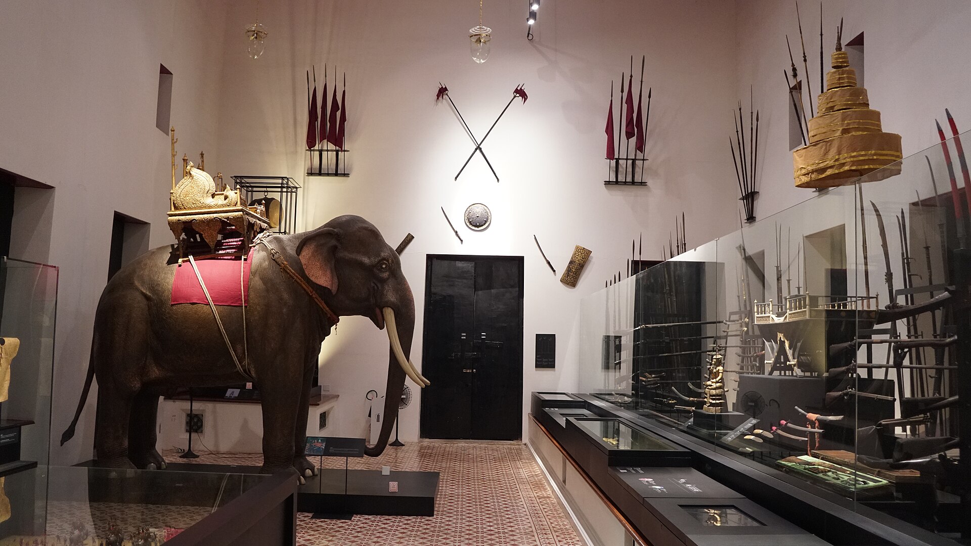 Siamese war elephant and antique weaponry (swords, polearms, shields and muskets).